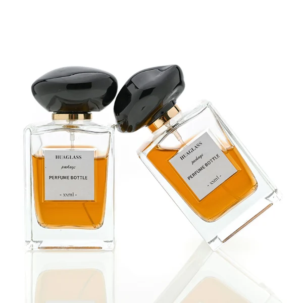 HUA0066 perfume bottles, rectangular clear glass with irregular black plastic caps, amber liquid, modern elegant design, 50ml 100ml.