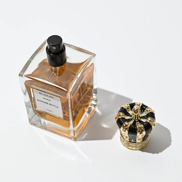 HUA0066 perfume bottles, rectangular clear glass with irregular black plastic caps, amber liquid, modern elegant design, 50ml 100ml.