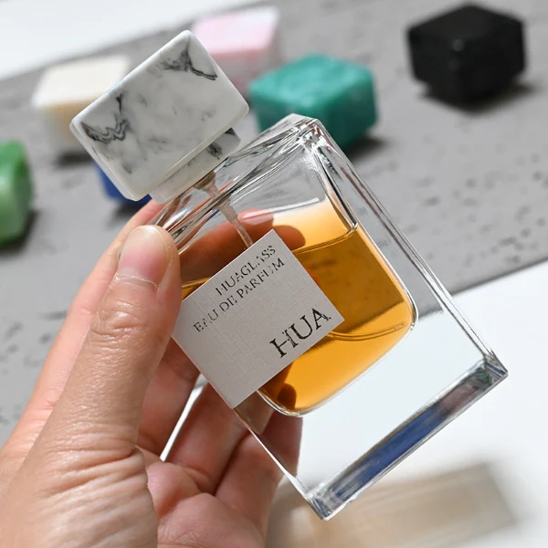 HUA0067 50ml perfume bottle, rectangular clear glass with rectangular colorful plastic cap, amber liquid, modern artistic design.