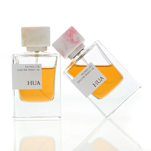 HUA0067 50ml perfume bottle, rectangular clear glass with rectangular colorful plastic cap, amber liquid, modern artistic design.
