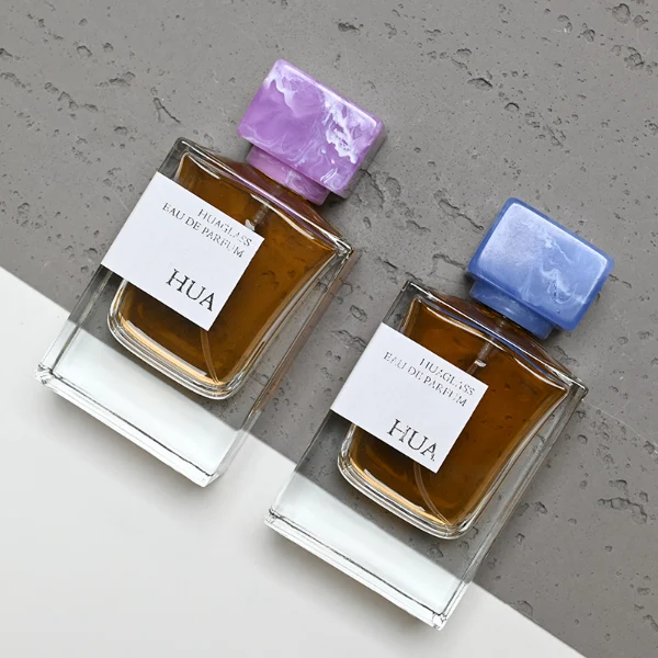 HUA0067 50ml perfume bottle, rectangular clear glass with rectangular colorful plastic cap, amber liquid, modern artistic design. Title: