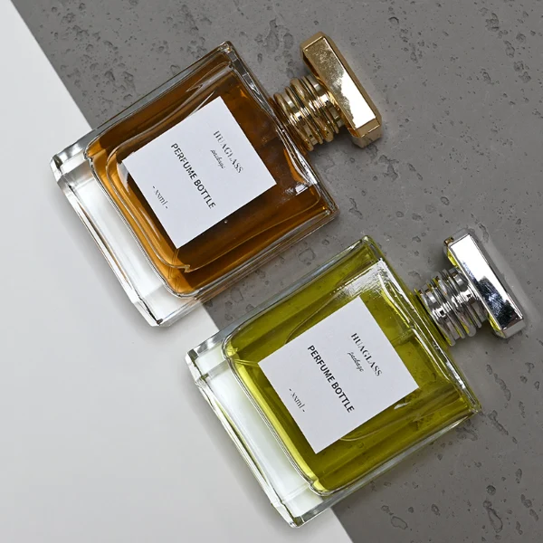 HUA0068 perfume bottles, rectangular clear glass with gold and silver rectangular plastic caps, amber and yellow liquids, modern elegant design, 50ml 100ml.