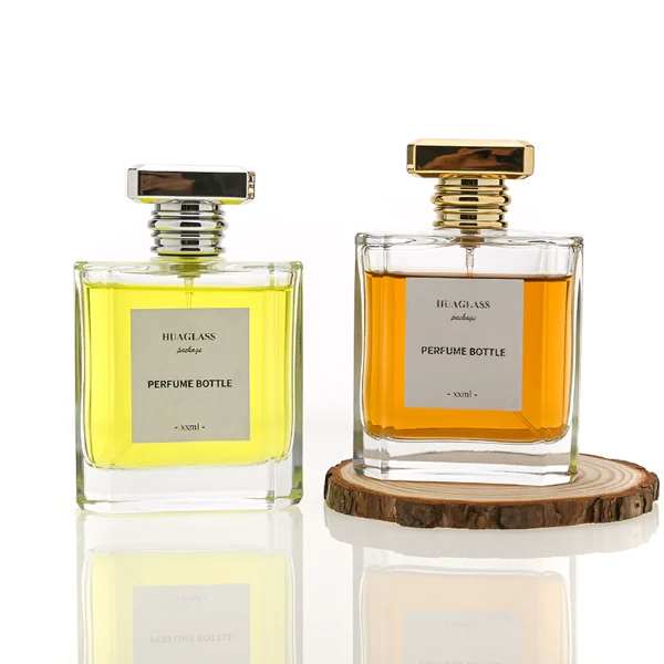 HUA0068 perfume bottles, rectangular clear glass with gold and silver rectangular plastic caps, amber and yellow liquids, modern elegant design, 50ml 100ml.