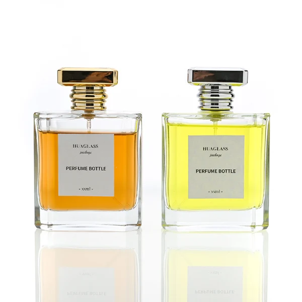 HUA0068 perfume bottles, rectangular clear glass with gold and silver rectangular plastic caps, amber and yellow liquids, modern elegant design, 50ml 100ml.