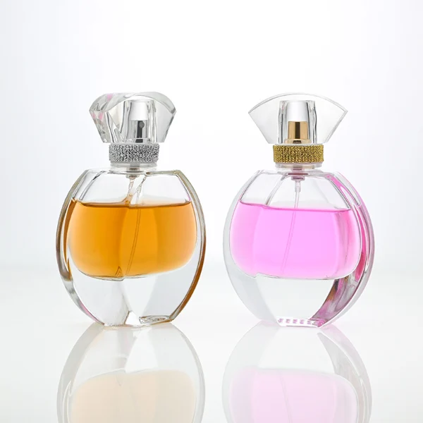 HUA0069 perfume bottles, oval clear glass with faceted plastic caps in silver/gold tones, amber and pink liquids, modern elegant design, 30ml 50ml 100ml.