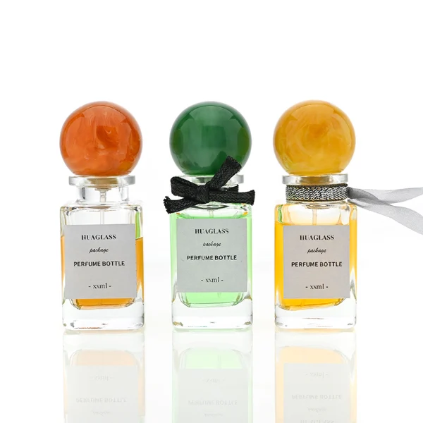 HUA0070 perfume bottles, rectangular clear glass with round colorful resin caps and metallic collars, pink and purple liquids, modern elegant design, 30ml 50ml 100ml.