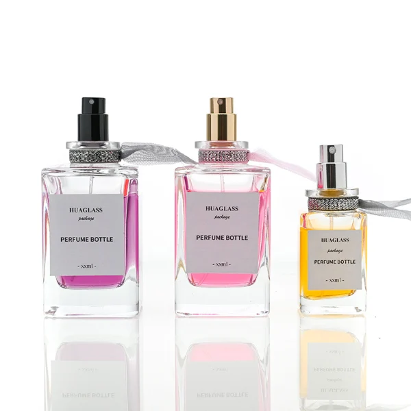 HUA0070 perfume bottles, rectangular clear glass with round colorful resin caps and metallic collars, pink and purple liquids, modern elegant design, 30ml 50ml 100ml.