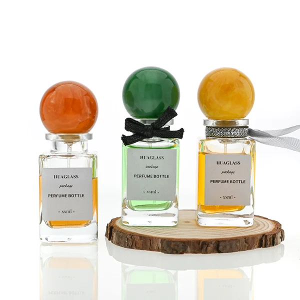 HUA0070 perfume bottles, rectangular clear glass with round colorful resin caps and metallic collars, pink and purple liquids, modern elegant design, 30ml 50ml 100ml.