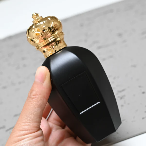 HUA0071 perfume bottle, black curved glass with gold crown-shaped zinc-aluminum alloy cap, rectangular front panel, luxurious classic design, available in 30 ml, 50 ml, and 100 ml