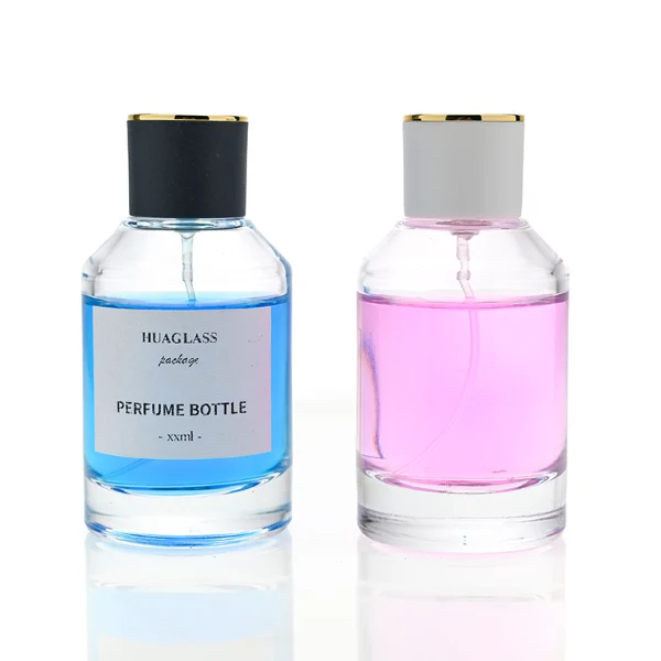 HUA0072 perfume bottle, clear cylindrical glass with liquid, white or black plastic cap with gold ring stripe on top, modern elegant design, available in 30 ml, 50 ml, and 100 ml