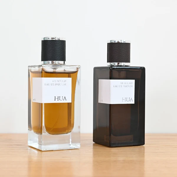 HUA0075 perfume bottle, rectangular clear glass, plastic cap with leather overlay, modern luxurious design, available in 30 ml, 50 ml, and 100 ml