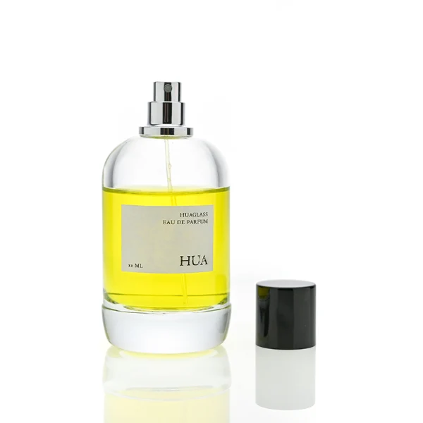 HUA0077 perfume bottle, rounded clear glass with liquid, glossy black aluminum magnetic cap, modern elegant design, available in 50 ml and 100 ml