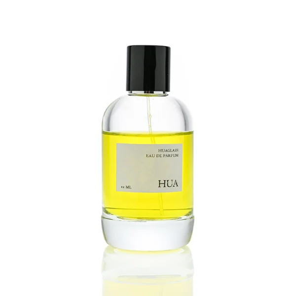 HUA0077 perfume bottle, rounded clear glass with liquid, glossy black aluminum magnetic cap, modern elegant design, available in 50 ml and 100 ml