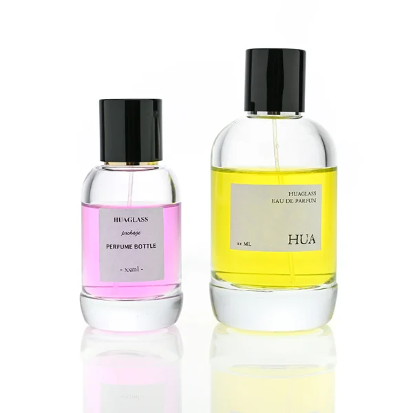HUA0077 perfume bottle, rounded clear glass with liquid, glossy black aluminum magnetic cap, modern elegant design, available in 50 ml and 100 ml