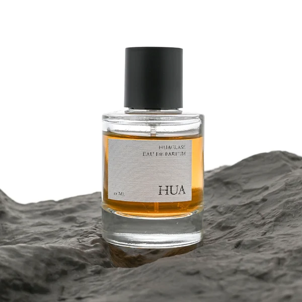 HUA0079 perfume bottle, cylindrical clear glass with liquid, glossy black aluminum magnetic cap, modern minimalist design, available in 30 ml, 50 ml, and 100 ml