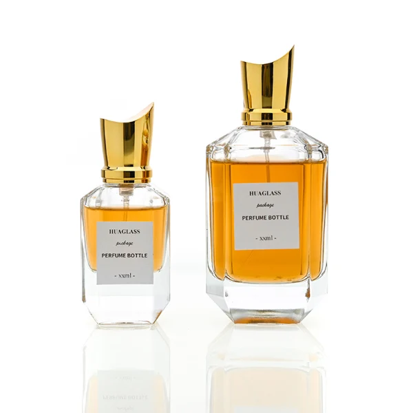 HUA0082 perfume bottle, cylindrical clear glass body, spherical glossy plastic cap with engraved patterns and glass neck, modern luxurious design, available in 30 ml, 50 ml, and 100 ml.