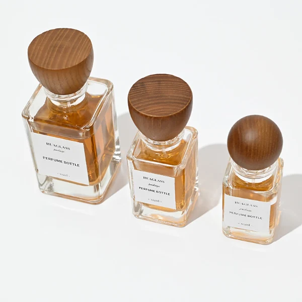 HUA0083 perfume bottle, square clear glass, wooden stopper-style cap, modern elegant design, available in 30 ml, 50 ml, and 100 ml