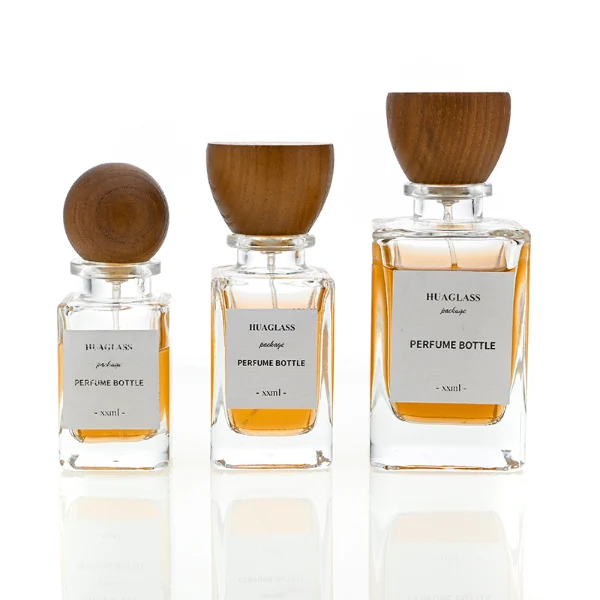 HUA0083 perfume bottle, square clear glass, wooden stopper-style cap, modern elegant design, available in 30 ml, 50 ml, and 100 ml