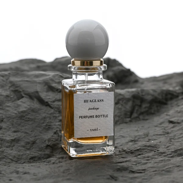 HUA0084 perfume bottle, rectangular glass with liquid, glossy plastic spherical cap, modern elegant design, available in 30 ml, 50 ml, and 100 ml