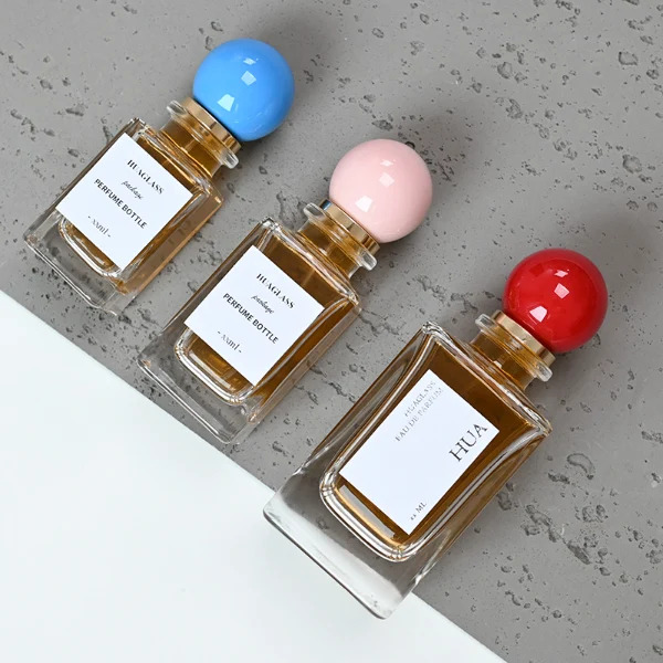 HUA0084 perfume bottle, rectangular glass with liquid, glossy plastic spherical cap, modern elegant design, available in 30 ml, 50 ml, and 100 ml
