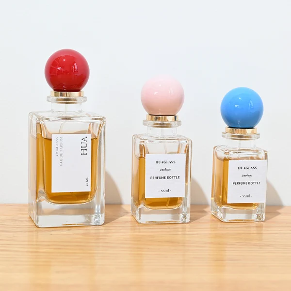 HUA0084 perfume bottle, rectangular glass with liquid, glossy plastic spherical cap, modern elegant design, available in 30 ml, 50 ml, and 100 ml