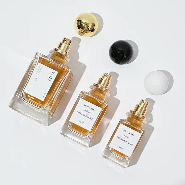 HUA0084 perfume bottle, rectangular glass with liquid, glossy plastic spherical cap, modern elegant design, available in 30 ml, 50 ml, and 100 ml