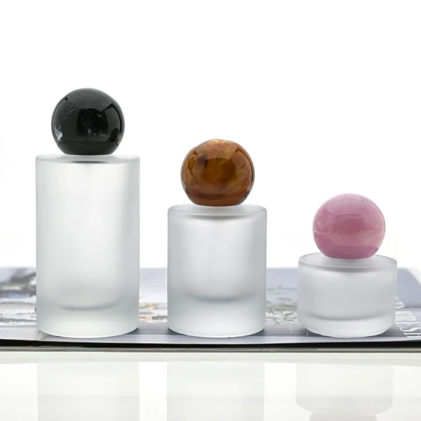 HUA0091 perfume bottle, cylindrical frosted white glass with liquid, colorful synthetic resin spherical cap, modern elegant design, available in 30 ml, 50 ml, and 100 ml