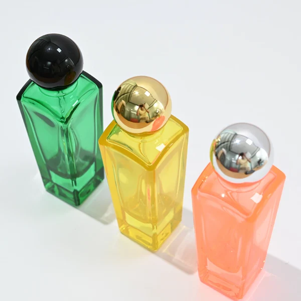 HUA0095 perfume bottle, tall rectangular colored glass body with embossed side details, glossy spherical plastic cap, modern artistic design, available in 50 ml.