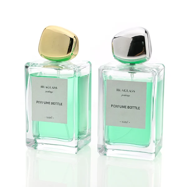 HUA0097 perfume bottle, rectangular glass body with liquid, glossy irregular rounded plastic cap, modern elegant design, available in 100 ml.