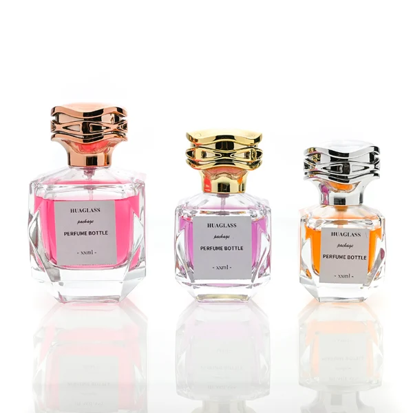 HUA0101 perfume bottle, faceted glass body with liquid, layered wave-shaped plastic cap, neck with bright metallic finish in gold, silver, or copper and FEA15-crimp specification, modern elegant design, available in 30 ml, 50 ml, and 100 ml.