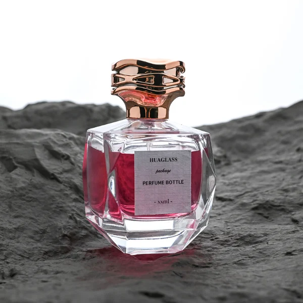 HUA0101 perfume bottle, faceted glass body with liquid, layered wave-shaped plastic cap, neck with bright metallic finish in gold, silver, or copper and FEA15-crimp specification, modern elegant design, available in 30 ml, 50 ml, and 100 ml.
