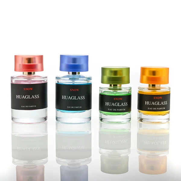 HUA0103 perfume bottle, cylindrical glass body with liquid, glossy colored plastic cap, neck with bright gold metallic finish, modern minimalist design, available in 30 ml, 50 ml, and 100 ml.