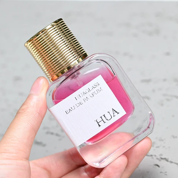 HUA0104 perfume bottle, rounded rectangular glass body with liquid and outer HUA label, cylindrical plastic cap with layered ring texture, modern elegant design, available in 30 ml, 50 ml, and 100 ml.
