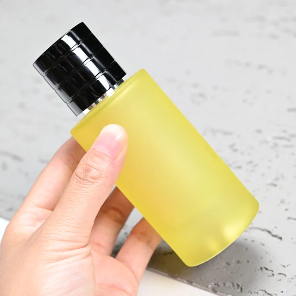 HUA0105 perfume bottle, cylindrical colored frosted glass body with aluminum cap featuring layered ring texture and glossy finish, modern minimalist design, available in 30 ml, 50 ml, and 100 ml.