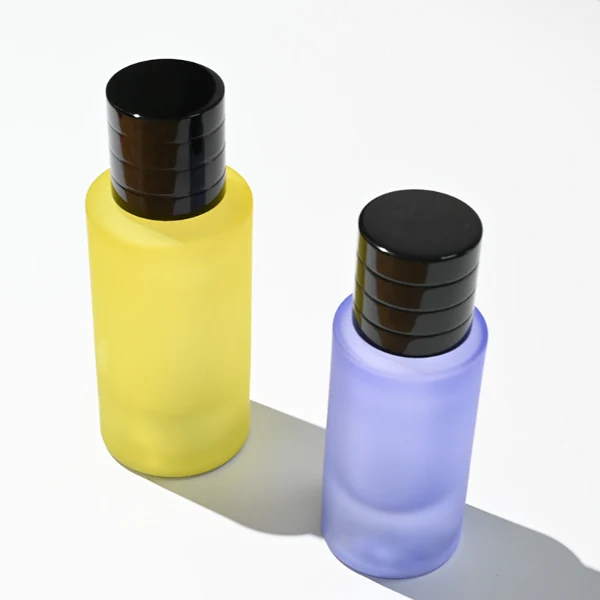 HUA0105 perfume bottle, cylindrical colored frosted glass body with aluminum cap featuring layered ring texture and glossy finish, modern minimalist design, available in 30 ml, 50 ml, and 100 ml.