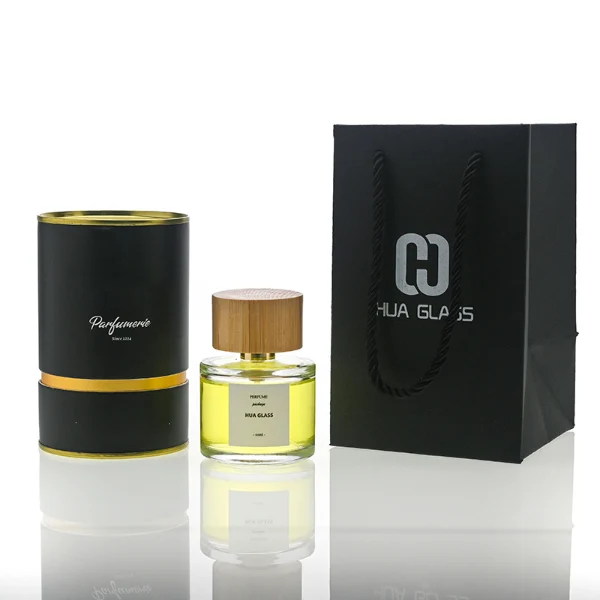 HUA0106 perfume bottle, cylindrical glass body with liquid, wide cylindrical bamboo cap with bright metallic neck, modern minimalist design, available in 30 ml, 50 ml, and 100 ml.