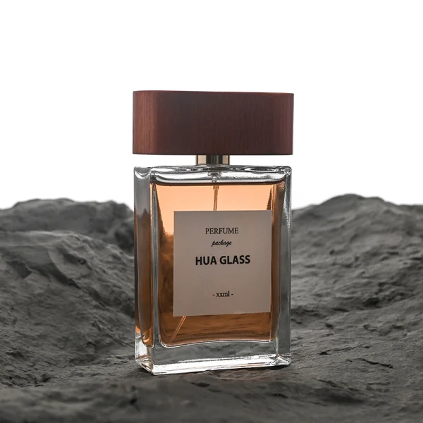 HUA0107 perfume bottle, rectangular glass body with liquid, wide flat wooden cap with metallic-finished neck, modern minimalist design, available in 50 ml and 100 ml.
