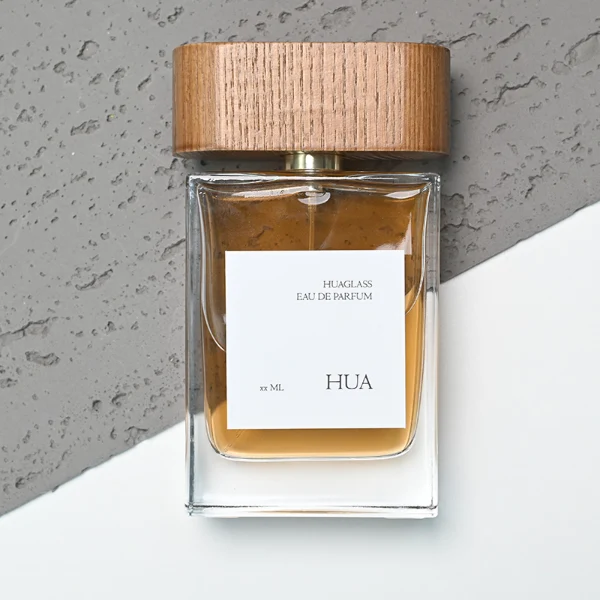 HUA0107 perfume bottle, rectangular glass body with liquid, wide flat wooden cap with metallic-finished neck, modern minimalist design, available in 50 ml and 100 ml.