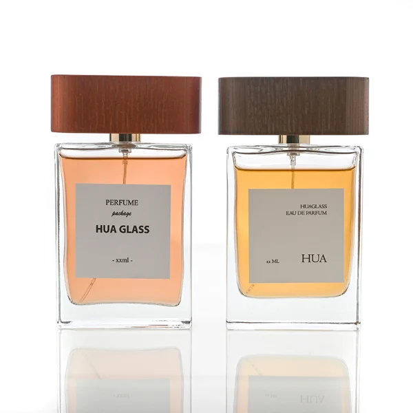 HUA0107 perfume bottle, rectangular glass body with liquid, wide flat wooden cap with metallic-finished neck, modern minimalist design, available in 50 ml and 100 ml.