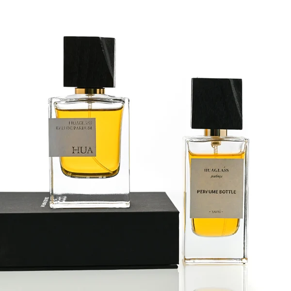 HUA0110 perfume bottle, rectangular glass body with liquid and outer label, black irregular rectangular bamboo cap with gold collar, modern elegant design, available in 50 ml.