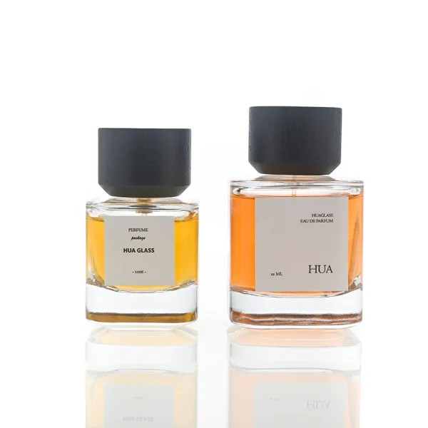 HUA0112 perfume bottle, cylindrical internally sprayed glass with liquid and outer label, wide black wooden cap, modern minimalist design, available in 30 ml, 50 ml, and 100 ml