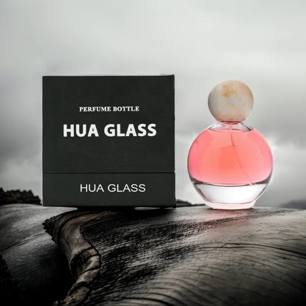 HUA0114 perfume bottle, transparent spherical glass with colorless liquid, resin marble-texture and black ball-shaped caps, label-free modern minimalist design, available in 30 ml, 50 ml, and 100 ml
