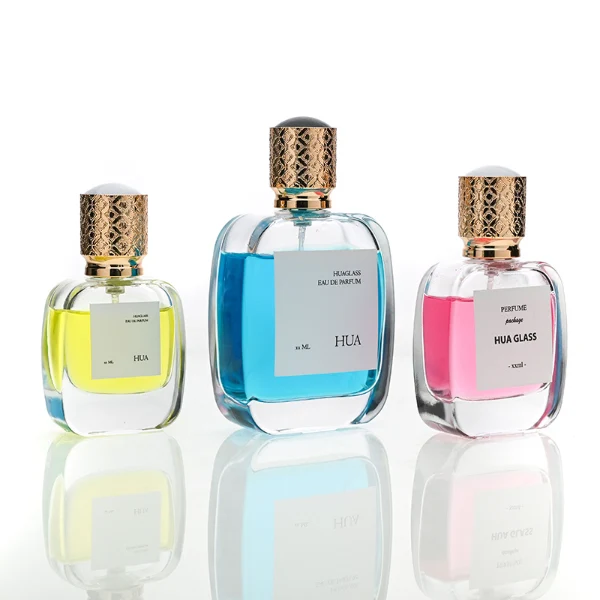 HUA0115 perfume bottle, rounded rectangular glass body with outer label, plastic cap with yellow engraved patterns, modern elegant design, available in 30 ml, 50 ml, and 100 ml.