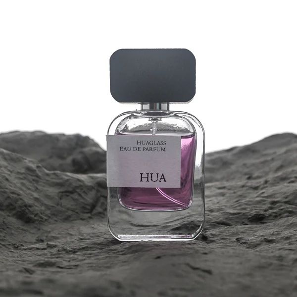 HUA0116 perfume bottle, rounded rectangular glass body with outer label, black rectangular plastic cap with yellow or silver neck accents, modern elegant design, available in 30 ml, 50 ml, and 100 ml.