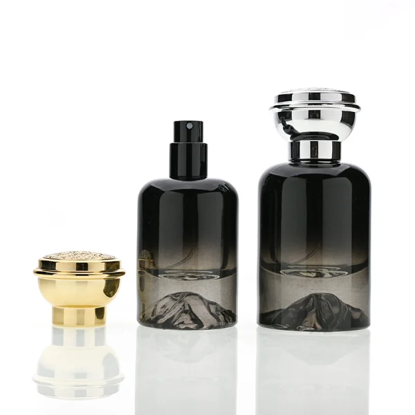 HUA0119 perfume bottle, gradient cylindrical glass with mountain-pattern base, glossy colored plastic cap in gold and silver tones, modern premium design, available in 30 ml, 50 ml, and 100 ml