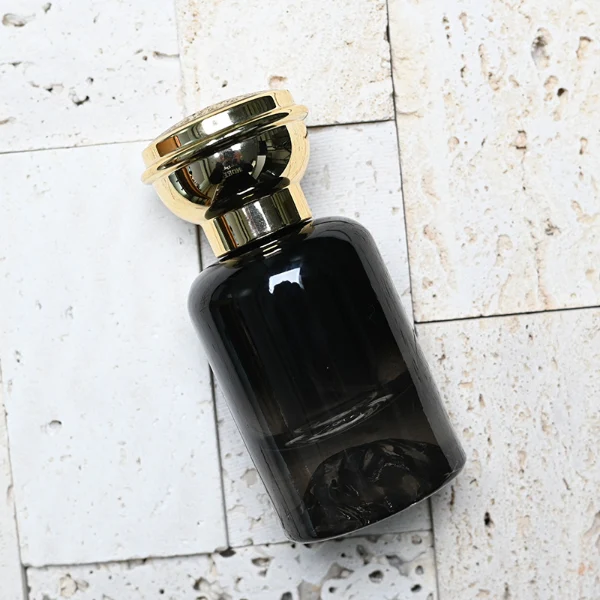 HUA0119 perfume bottle, gradient cylindrical glass with mountain-pattern base, glossy colored plastic cap in gold and silver tones, modern premium design, available in 30 ml, 50 ml, and 100 ml