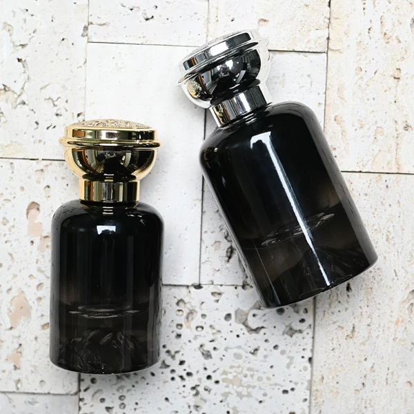 HUA0119 perfume bottle, gradient cylindrical glass with mountain-pattern base, glossy colored plastic cap in gold and silver tones, modern premium design, available in 30 ml, 50 ml, and 100 ml