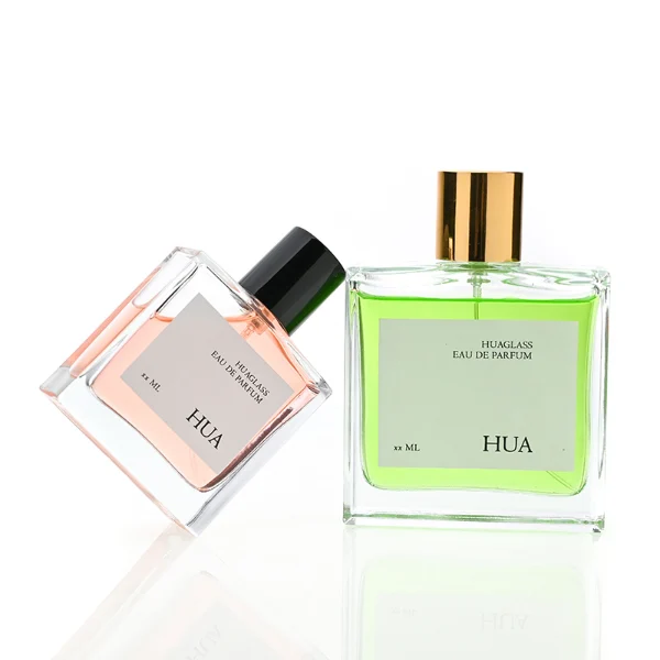 HUA0121 perfume bottle, square clear glass with outer label, aluminum cylindrical cap in black and gold finishes, modern minimalist luxury design, available in 30 ml, 50 ml, and 100 ml