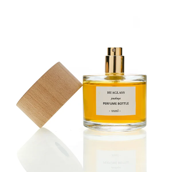 HUA0123 perfume bottle, rounded cylindrical clear glass with outer label, wide wooden cylindrical cap, minimalist modern design, available in 30 ml, 50 ml, and 100 ml