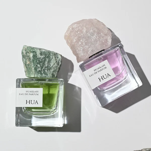 HUA0124 perfume bottle, square clear glass with outer label, irregular crystal stone cap with natural raw texture, contemporary decorative design, available in 30 ml, 50 ml, and 100 ml